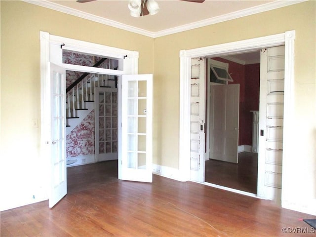 spare room featuring ornamental molding, ceiling fan, wood finished floors, baseboards, and stairs