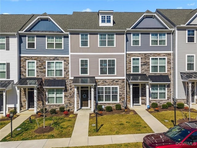 townhome / multi-family property with a standing seam roof, stone siding, metal roof, and roof with shingles