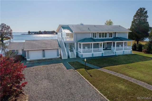 view of front of home with driveway, a garage, a porch, stairway, and a front lawn