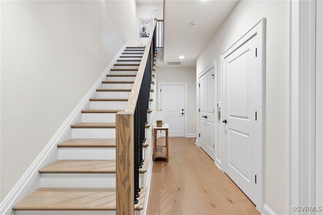 staircase featuring recessed lighting, wood finished floors, visible vents, and baseboards