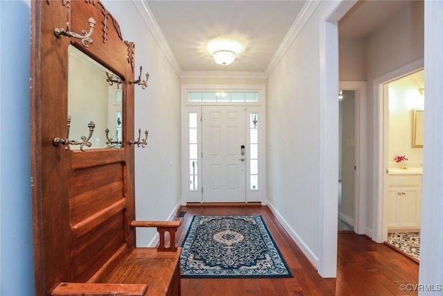 foyer entrance featuring crown molding, baseboards, and wood finished floors