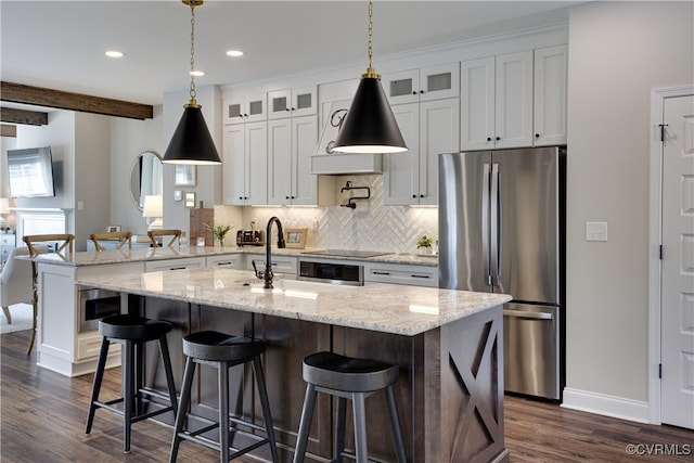 kitchen featuring dark wood-style floors, glass insert cabinets, decorative backsplash, and freestanding refrigerator