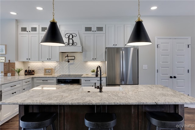 kitchen featuring white cabinets, a sink, and freestanding refrigerator