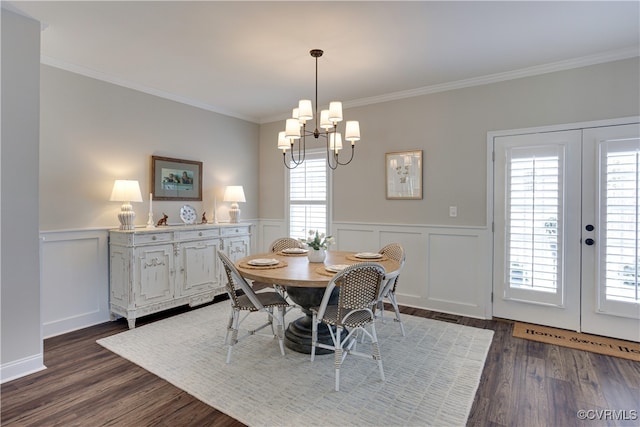 dining room featuring a chandelier, french doors, dark wood-type flooring, and ornamental molding