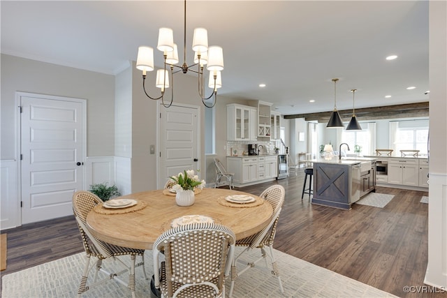 dining space featuring a wainscoted wall, dark wood finished floors, recessed lighting, a decorative wall, and ornamental molding