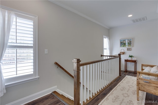 staircase with ornamental molding, visible vents, baseboards, and wood finished floors