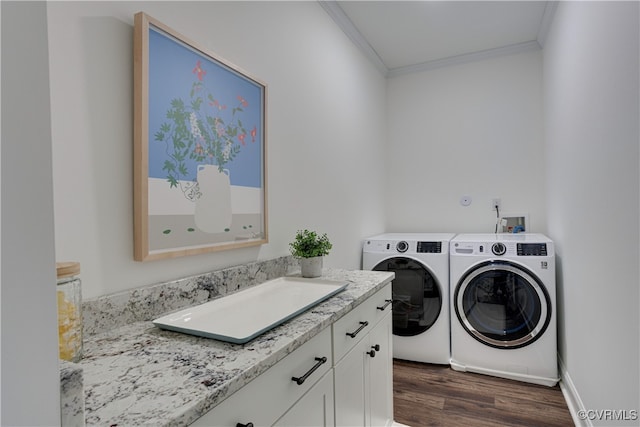 clothes washing area with crown molding, independent washer and dryer, a sink, and dark wood-style floors