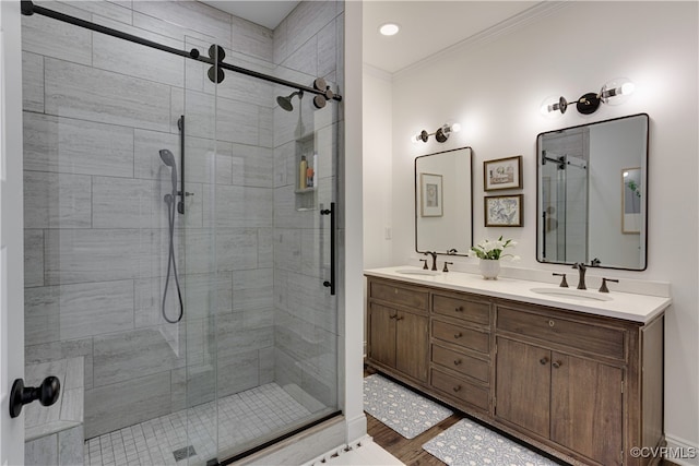 bathroom featuring crown molding, a sink, and a shower stall