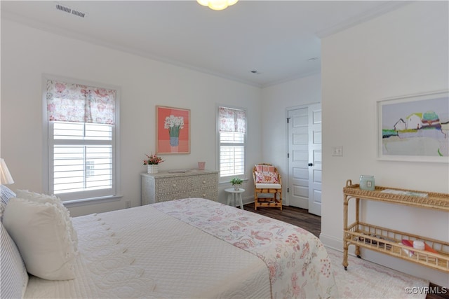 bedroom featuring ornamental molding, multiple windows, visible vents, and baseboards