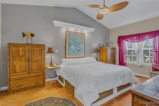 bedroom featuring ceiling fan, vaulted ceiling, baseboards, and wood finished floors