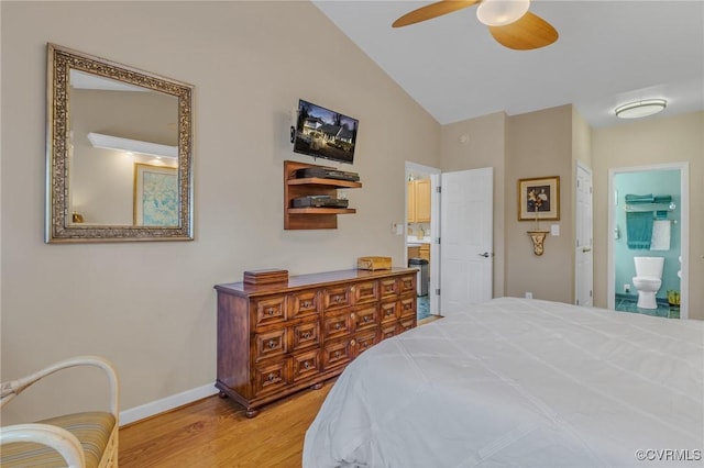 bedroom featuring baseboards, connected bathroom, ceiling fan, wood finished floors, and vaulted ceiling