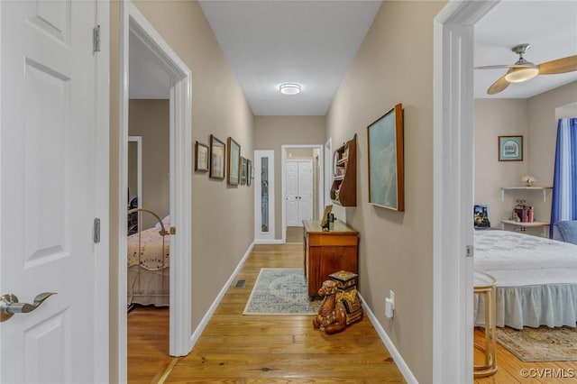 hallway with light wood-style flooring and baseboards