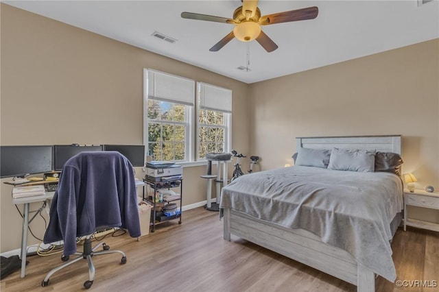 bedroom with visible vents, ceiling fan, baseboards, and wood finished floors