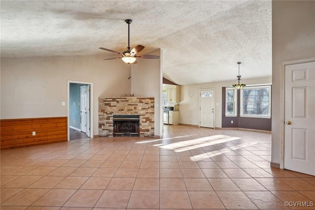 unfurnished living room with light tile patterned floors, a stone fireplace, and a textured ceiling