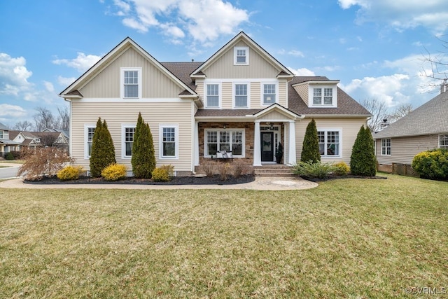 view of front of house with a shingled roof and a front yard