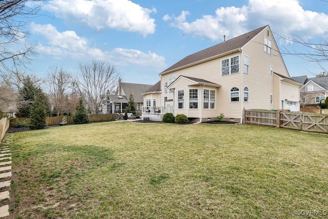 back of house with crawl space, a fenced backyard, and a lawn