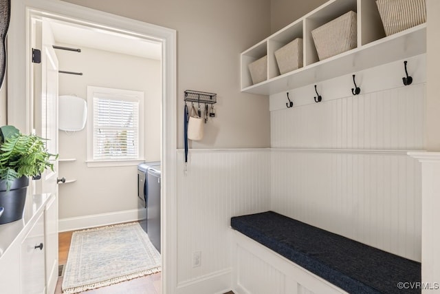 mudroom with a wainscoted wall, independent washer and dryer, and wood finished floors