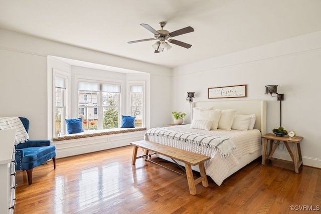 bedroom featuring baseboards, a ceiling fan, and light wood-style floors