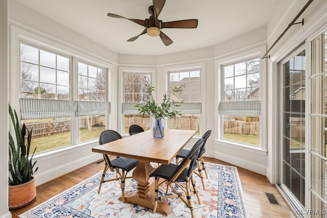 sunroom / solarium with a ceiling fan, visible vents, and a wealth of natural light