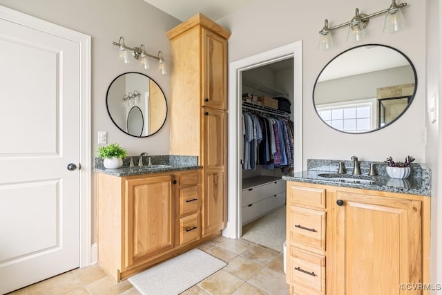 bathroom with tile patterned flooring, two vanities, and a sink