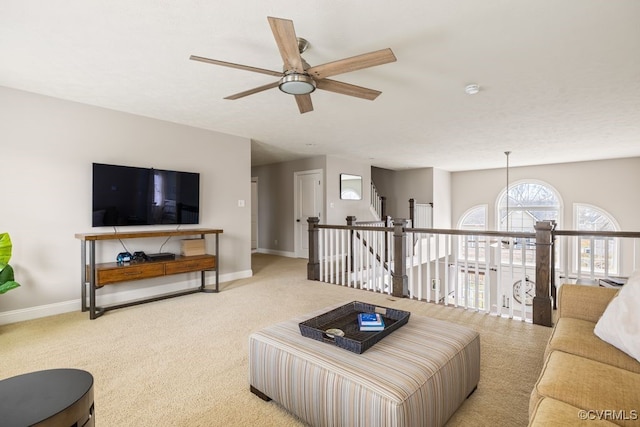 living room with carpet floors, baseboards, and a ceiling fan