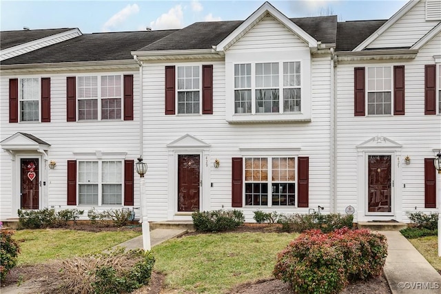 multi unit property featuring a front lawn and a shingled roof