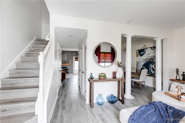 entryway with baseboards, stairway, ornate columns, and wood finished floors