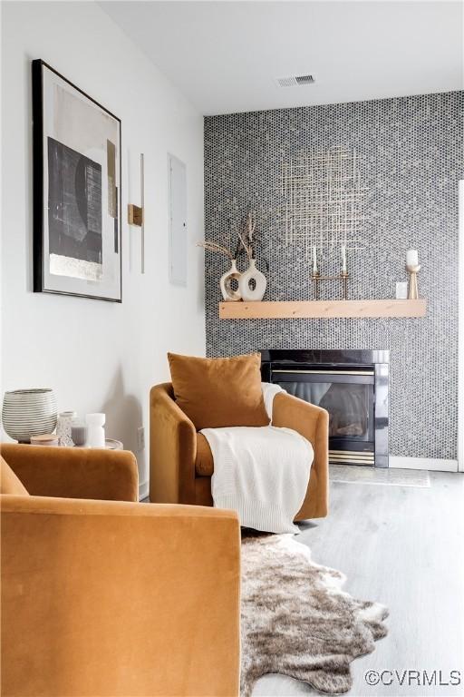 living area with visible vents and a tiled fireplace