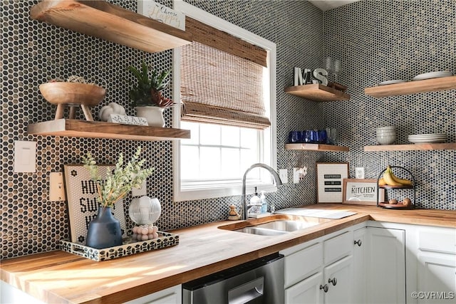 kitchen featuring decorative backsplash, dishwasher, wooden counters, open shelves, and a sink