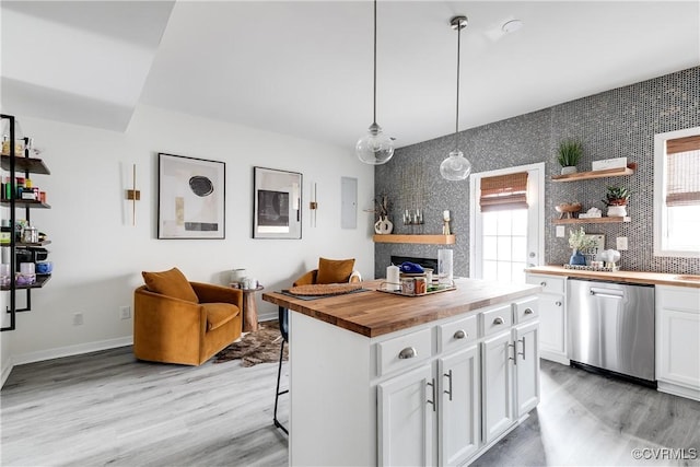 kitchen featuring white cabinetry, plenty of natural light, wood counters, and stainless steel dishwasher