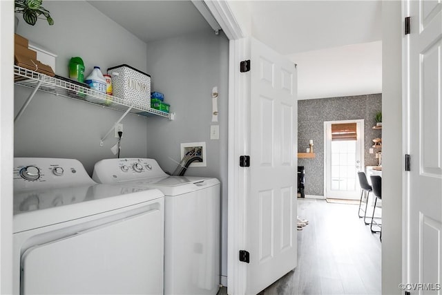 laundry area featuring laundry area, independent washer and dryer, wood finished floors, and wallpapered walls