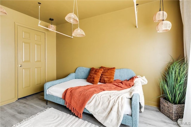 bedroom featuring baseboards and wood finished floors