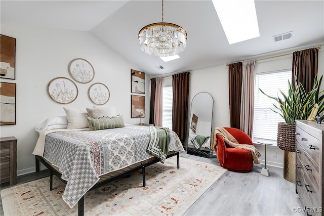 bedroom featuring baseboards, visible vents, wood finished floors, vaulted ceiling, and a chandelier