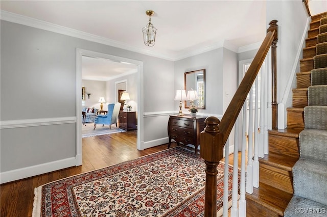 foyer with stairway, baseboards, ornamental molding, and wood finished floors