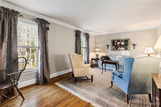 sitting room featuring wood finished floors, a wealth of natural light, and crown molding