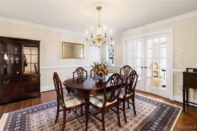 dining room with baseboards, french doors, ornamental molding, dark wood-style floors, and an inviting chandelier