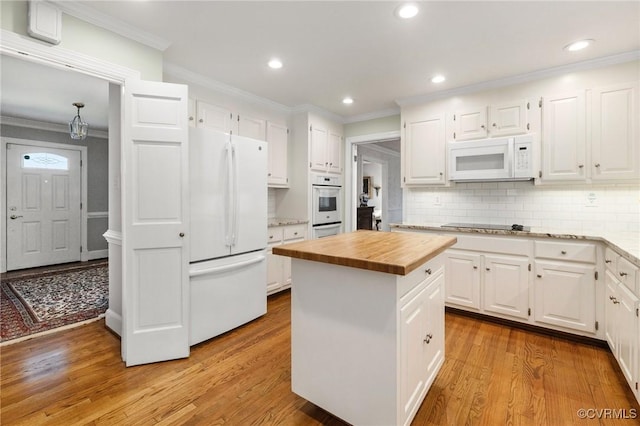 kitchen with white appliances, butcher block counters, white cabinetry, light wood-style floors, and crown molding