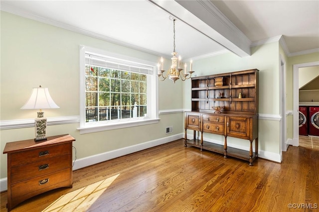 dining room featuring baseboards, washing machine and dryer, ornamental molding, and wood finished floors