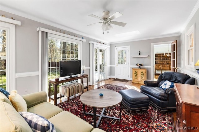 living area featuring crown molding, plenty of natural light, and wood finished floors