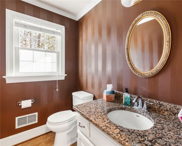 bathroom with visible vents, toilet, ornamental molding, vanity, and baseboards