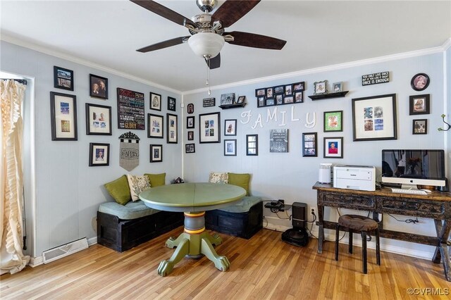 office area featuring ornamental molding, light wood-style flooring, and visible vents