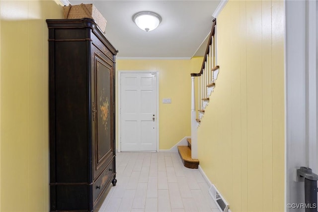 hall with ornamental molding, visible vents, baseboards, and stairs