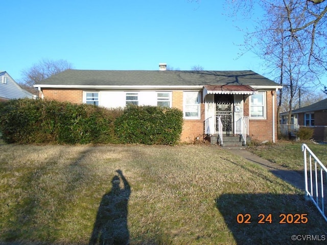 view of front of property with brick siding and a front lawn