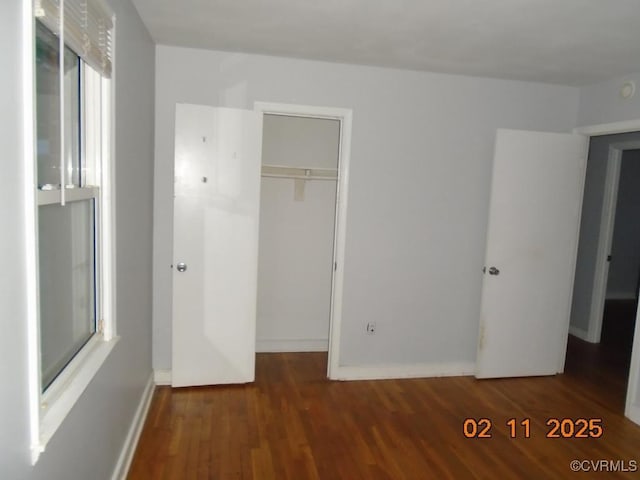 unfurnished bedroom featuring a closet, baseboards, and wood finished floors