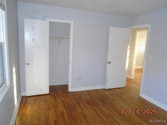 unfurnished bedroom featuring a closet, baseboards, and wood finished floors