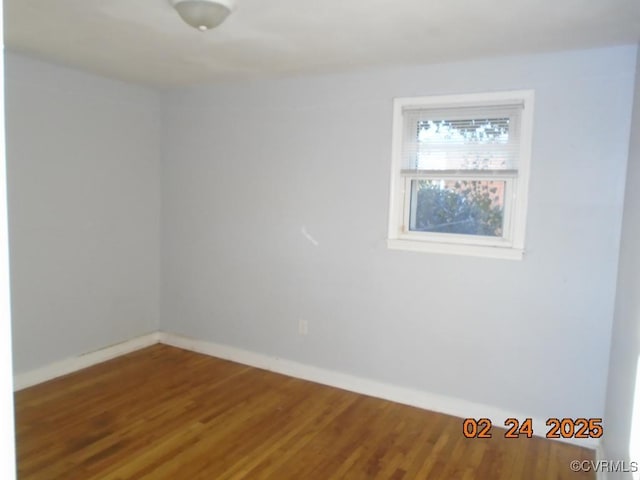 spare room featuring wood finished floors and baseboards