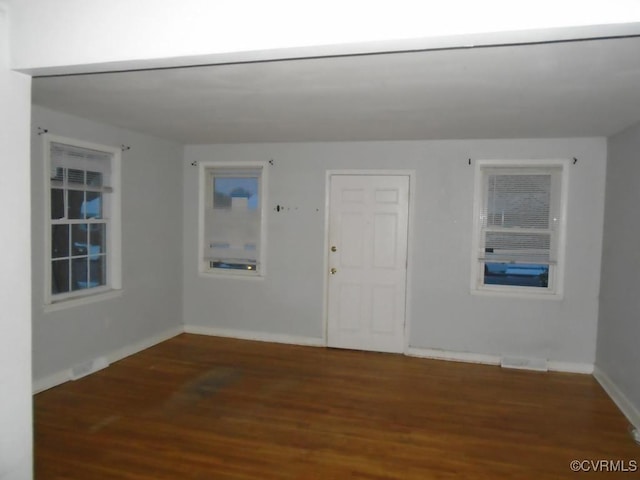 interior space with visible vents, baseboards, and wood finished floors