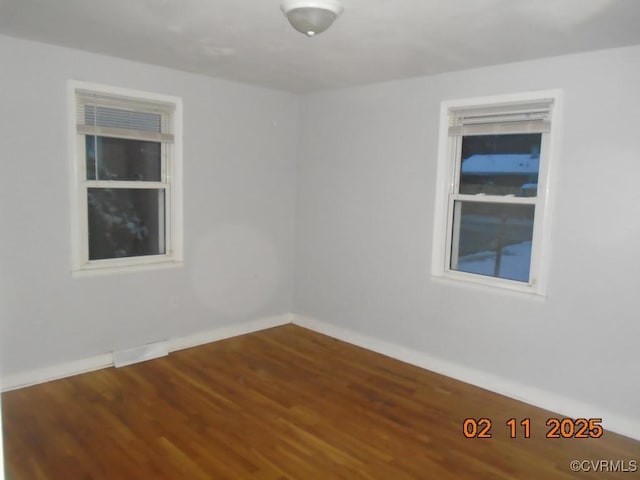 empty room featuring baseboards and wood finished floors