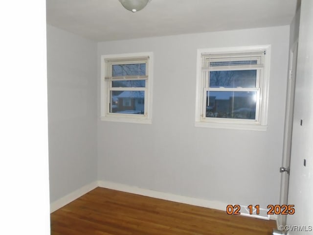 empty room featuring dark wood-style floors and baseboards