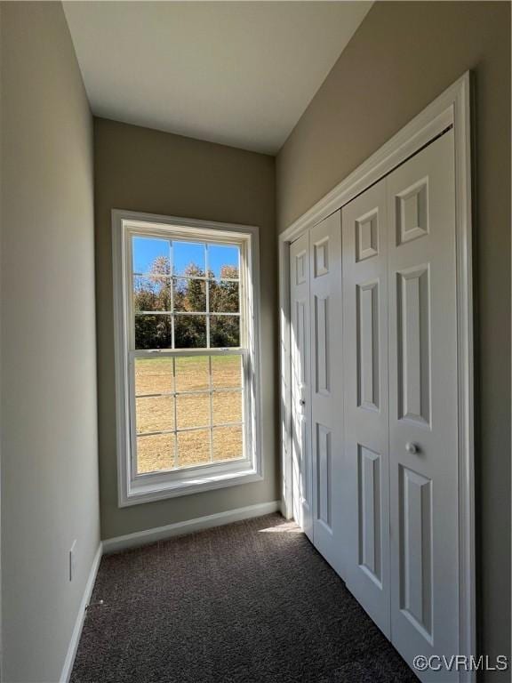 doorway with carpet floors and baseboards